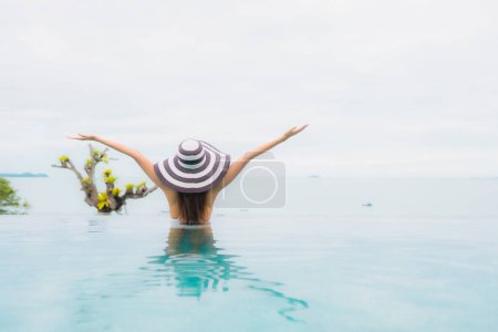 Téléchargez les photos : Portrait belle jeune femme asiatique sourire relax et loisirs autour de la piscine extérieure en station balnéaire - en image libre de droit
