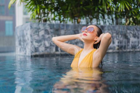 Foto de Retrato hermosa joven mujer asiática relajarse ocio alrededor de la piscina en el complejo hotelero - Imagen libre de derechos