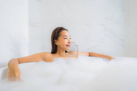 Foto de Retrato hermosa joven mujer asiática relajarse disfrutar en la bañera en el interior del baño - Imagen libre de derechos