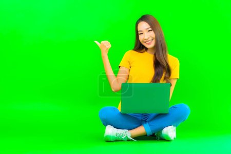 Photo for Portrait beautiful young asian woman use computer laptop on green isolated background - Royalty Free Image