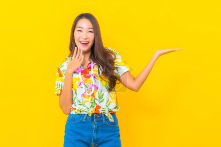Téléchargez les photos : Portrait belle jeune femme asiatique porter chemise colorée sur fond jaune pour le festival sonkran en Thaïlande - en image libre de droit