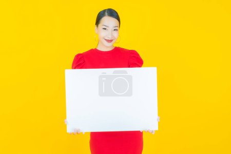 Foto de Retrato hermosa joven asiática mujer con vacío blanco cartel en color de fondo - Imagen libre de derechos
