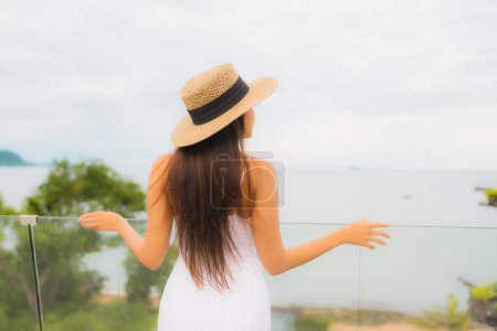 Photo for Portriat beautiful young asian woman happy smile around balcony with sea view background - Royalty Free Image
