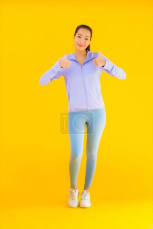 Photo for Portrait beautiful young asian sport woman with sportwear ready for exercise on yellow isolated background - Royalty Free Image