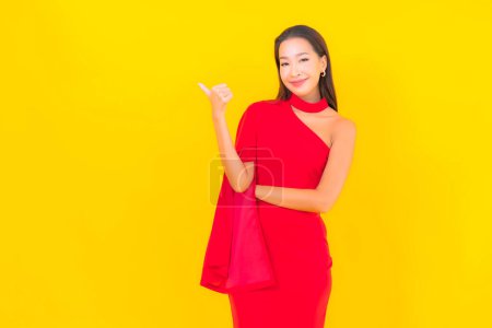 Foto de Retrato hermosa joven asiática mujer sonrisa con acción sobre amarillo aislado fondo - Imagen libre de derechos