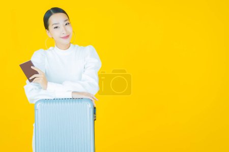Téléchargez les photos : Portrait belle jeune femme asiatique avec sac à bagages et passeport prêt pour le voyage - en image libre de droit