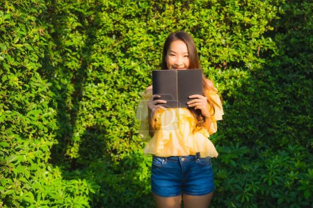 Foto de Joven asiático mujer leer libro alrededor al aire libre jardín naturaleza vista - Imagen libre de derechos