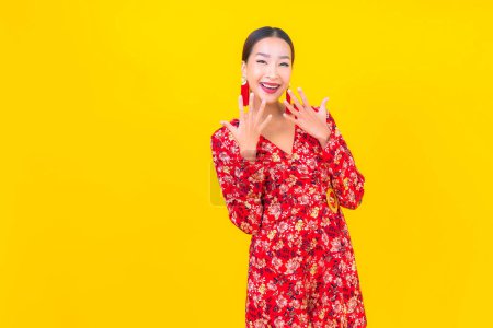 Téléchargez les photos : Portrait belle jeune femme asiatique sourire en action en chinois nouvelle année concept sur fond de couleur - en image libre de droit