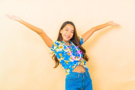 Foto de Retrato hermosa joven asiática mujer desgaste colorido camisa para songkran festival en color fondo - Imagen libre de derechos