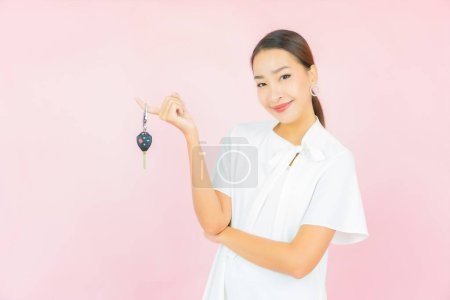 Foto de Retrato hermosa joven asiática mujer con coche llave en rosa color de fondo - Imagen libre de derechos