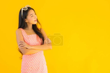 Téléchargez les photos : Portrait belle jeune femme asiatique sourire heureux sur fond jaune isolé - en image libre de droit