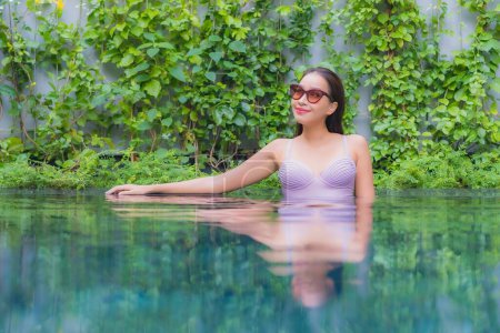 Téléchargez les photos : Portrait belle jeune asiatique femme relax sourire loisirs autour de piscine extérieure dans hotel resort - en image libre de droit