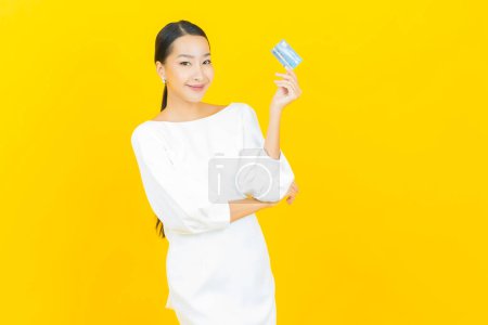 Foto de Retrato hermosa joven asiática mujer sonrisa con tarjeta de crédito en color de fondo - Imagen libre de derechos