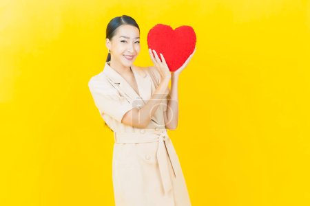 Photo for Portrait beautiful young asian woman smile with heart pillow shape on color background - Royalty Free Image