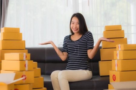 Téléchargez les photos : Portrait belle jeune femme asiatique avec emballage de boîte de colis en carton conteneur préparer pour l'expédition pour le client achats en ligne dans le salon - en image libre de droit
