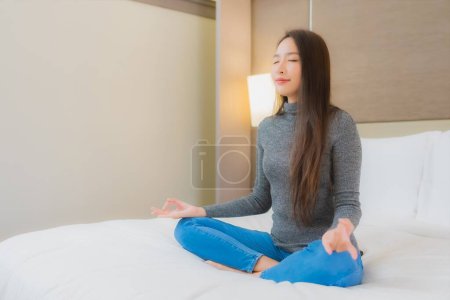 Foto de Retrato hermosa joven mujer asiática meditación en la cama en el interior del dormitorio - Imagen libre de derechos