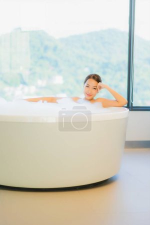 Téléchargez les photos : Portrait belle jeune femme asiatique se détendre loisirs profiter dans la baignoire à la salle de bain et WC intérieur - en image libre de droit
