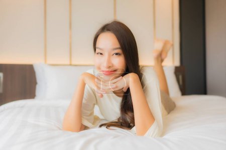 Photo for Portrait beautiful young asian woman smile relax leisure on bed in bedroom interior - Royalty Free Image