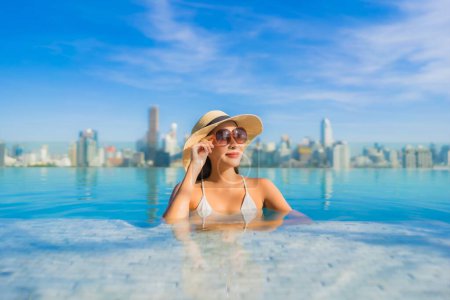 Photo for Portrait beautiful young asian woman smile relax leisure around outdoor swimming pool with city view - Royalty Free Image
