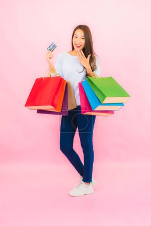 Photo for Portrait beautiful young asian woman with colorful shopping bag on pink color isolated background - Royalty Free Image