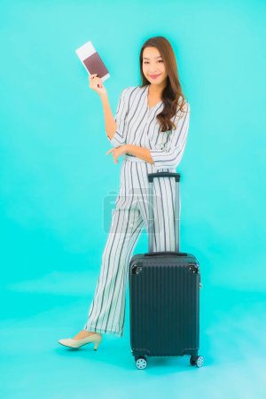 Téléchargez les photos : Portrait belle jeune femme asiatique avec passeport bagage et carte d'embarquement prêt pour voyager sur fond bleu - en image libre de droit