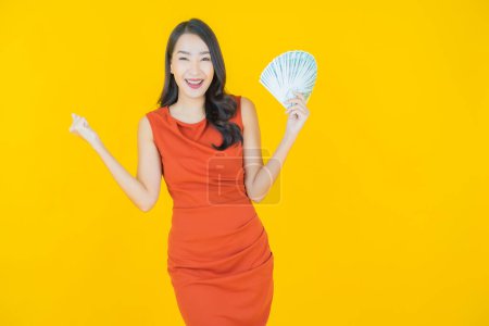 Photo for Portrait beautiful young asian woman smile with a lot of cash and money on color background - Royalty Free Image