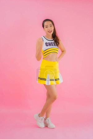 Photo for Portrait beautiful young asian woman cheerleader on pink isolated background - Royalty Free Image