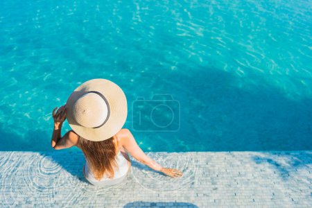 Foto de Retrato hermosa joven mujer asiática sonrisa relajarse ocio alrededor de piscina al aire libre con vista a la ciudad - Imagen libre de derechos