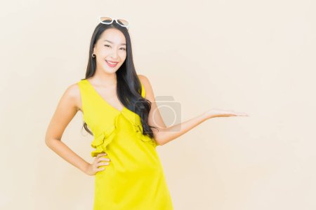 Foto de Retrato hermosa joven asiática mujer sonrisa con acción en crema fondo - Imagen libre de derechos