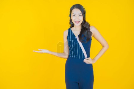 Porträt schöne junge asiatische Frau mit Call Center Kundenbetreuungszentrum auf gelbem Hintergrund