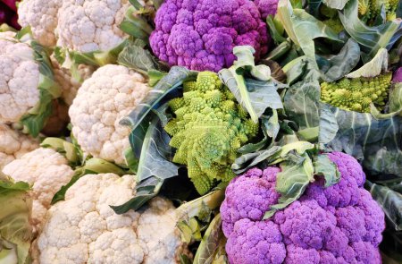 A selection of various types of cauliflower, including romanesco, regular and purple