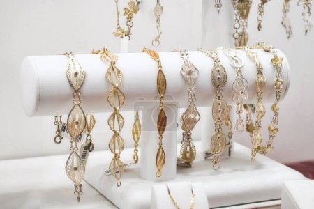 A collection of gold and silver filigree women's bracelets on display in a retail jewellery shop