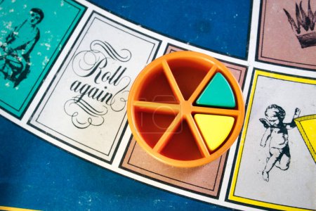 Photo for London, UK - 07 April 2019: A board games tournament - Overhead close-up shot of classic board game Trivial Pursuit with colored plastic pieces of different colors - Royalty Free Image