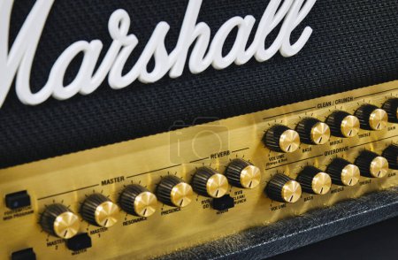 Photo for Close-up of a Marshall stack amplifier head showing the white logo on the grill mesh and rows of buttons - Royalty Free Image