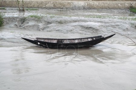 Isoliertes Fischerboot am Ufer eines Flusses in einem Mangroven-Feuchtgebiet