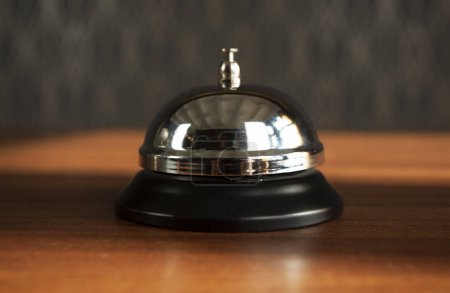 Photo for Service bell vintage with bokeh background. Hand ringing for call assistance on demand and services. - Royalty Free Image