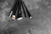 Set of makeup brushes, cosmetics, makeup tools on a dark gray spotted background. flat lay, top view. Poster #652916764