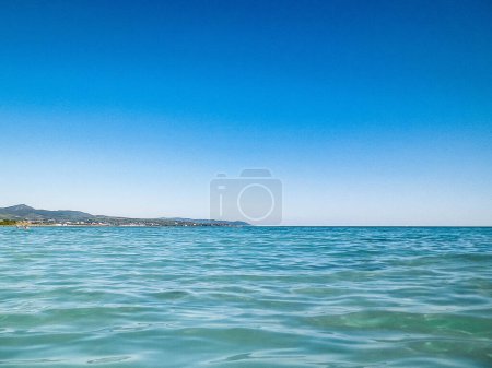 Foto de Costa en Italia en Vada, el agua del mar Tirreno sobre fondo azul cielo. Concepto de vacaciones y naturaleza. Copiar espacio. - Imagen libre de derechos