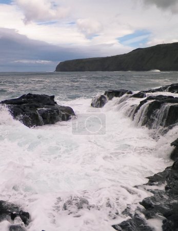 Foto de Olas chocando contra rocas. Clima ventoso en San Miguel, Azores. Piscinas Naturais Parque Natural de Caneiros. - Imagen libre de derechos