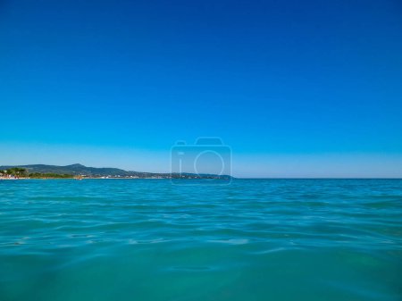 Photo for Coast in Italy in Vada, Tyrrhenian sea water on blue sky background. Vacations and nature concept. Copy space. - Royalty Free Image
