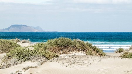 Beach, Atlantic Ocean and La Graciosa island in Caleta de Famara, Lanzarote Canary Islands. Beach in Caleta de Famara is very popular among surfers. Copy space.