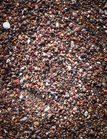 Sand and gravel on a seashore as nature background. Copy space.
