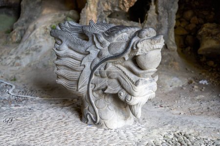 Téléchargez les photos : Gros plan d'une sculpture en pierre d'une tête de dragon dans un parc - en image libre de droit