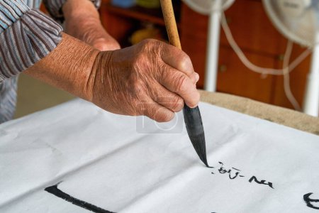 Téléchargez les photos : Un vieux calligraphe chinois écrit des personnages de calligraphie, crée des œuvres de calligraphie - en image libre de droit