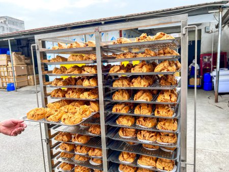 Téléchargez les photos : Petits pains bruns cuits à la vapeur fraîchement cuits en lots dans une usine de transformation des aliments - en image libre de droit