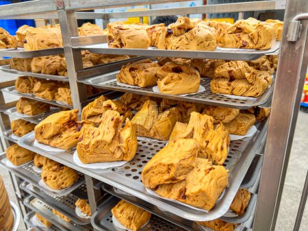 Téléchargez les photos : Petits pains bruns cuits à la vapeur fraîchement cuits en lots dans une usine de transformation des aliments - en image libre de droit