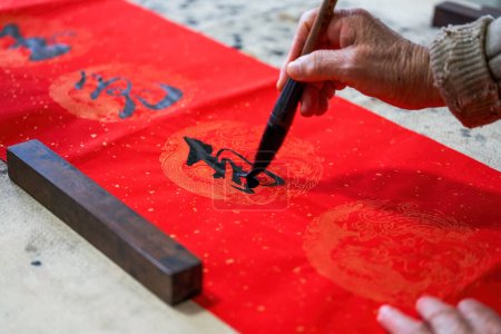 Photo for An old Chinese calligrapher is writing Chinese Spring Festival couplets - Royalty Free Image