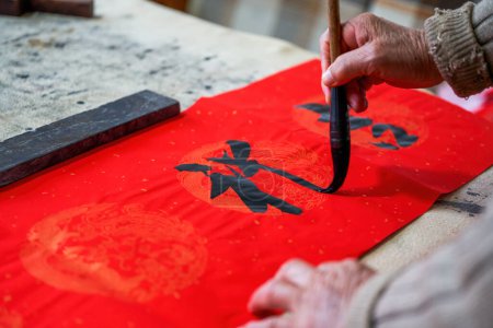 Photo for An old Chinese calligrapher is writing Chinese Spring Festival couplets - Royalty Free Image