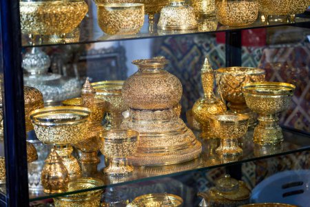 Southeast Asian style gold containers and utensils placed in the cabinet