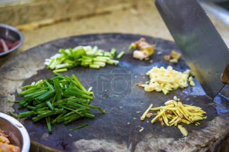 Ingredientes para saltear preparados sobre tabla de cortar en la cocina china